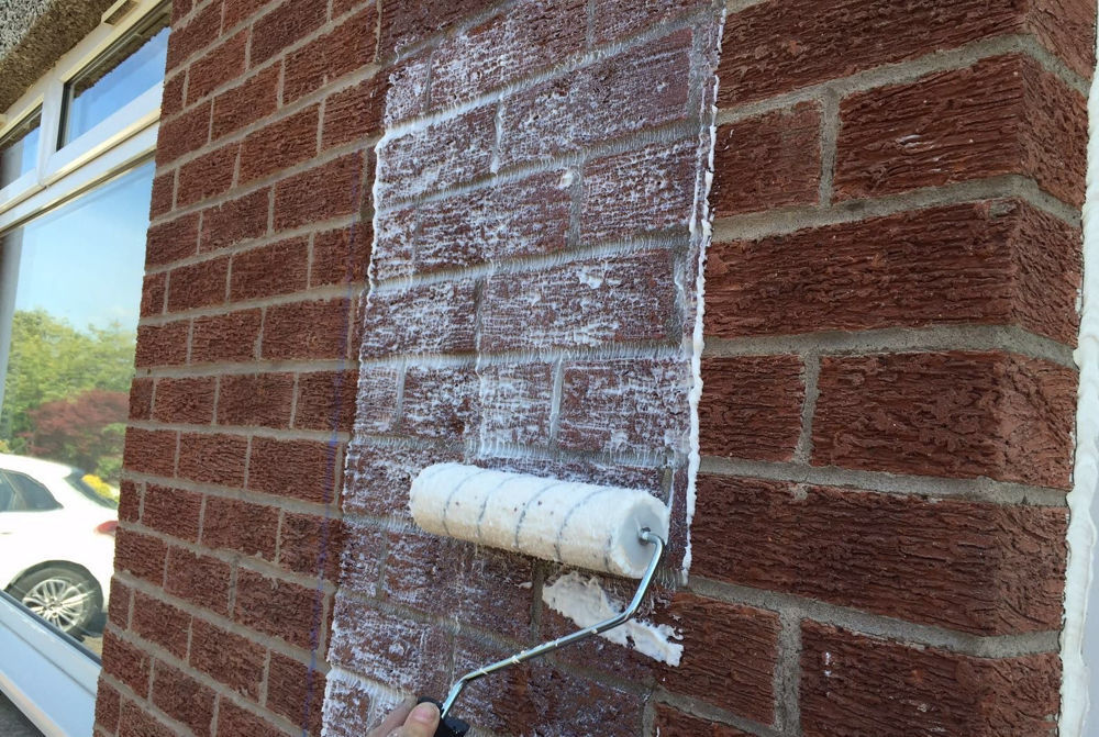 Applying waterproofing masonry cream to a wall